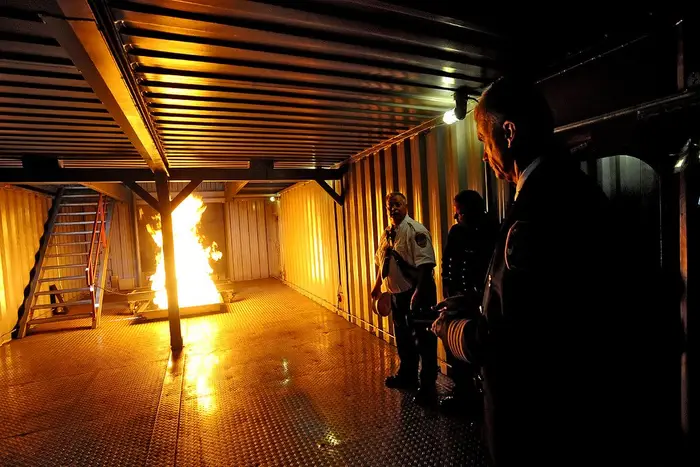 Chief of Department Edward Kilduff gets a demonstration of a simulated engine room fire aboard the simulator. The fire intensity and duration is controlled by a remote control.